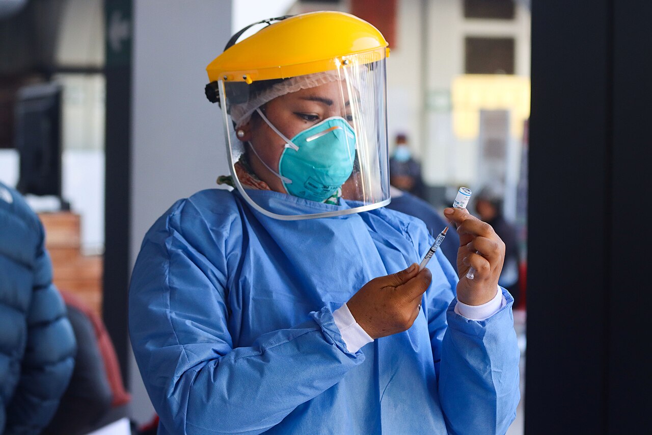 Member of Vaccination Brigade preparing Sinopharm vaccine syringe against COVID-19, Cuzco