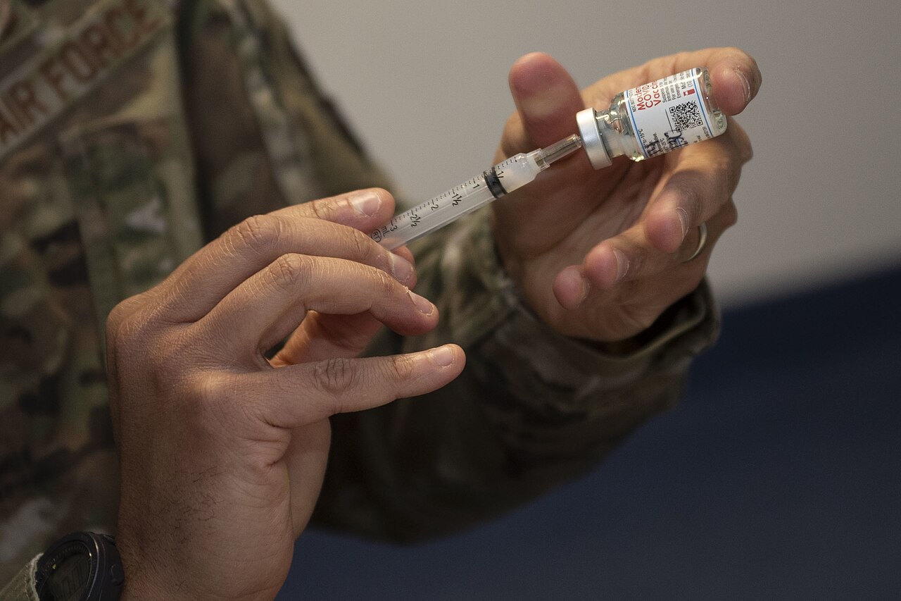 U.S. Air Force Senior Master Sgt. Shareef Cardwell, 52nd Medical Operations Squadron superintendent, fills a syringe during a COVID-19 vaccination dis